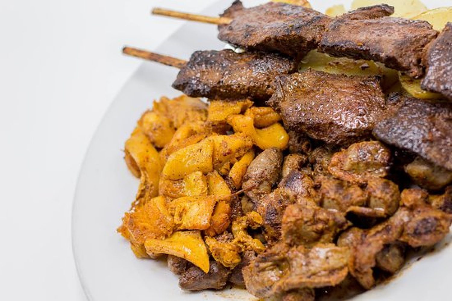 Plato mixto Anticuchos con variedad, brochetas de carne asada acompañadas de salsas y guarniciones.