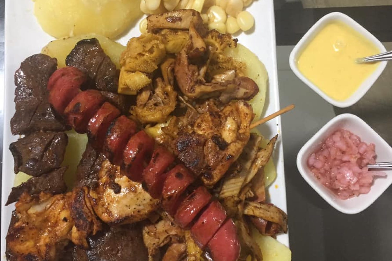 Variedad de Sumaq Park Plato con variedad de comidas peruanas, como ceviche, lomo saltado, tamales y picarones.
